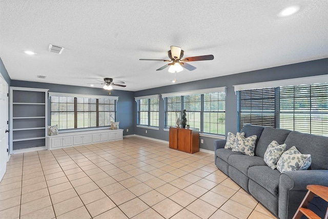 unfurnished living room featuring a textured ceiling, ceiling fan, and light tile patterned flooring