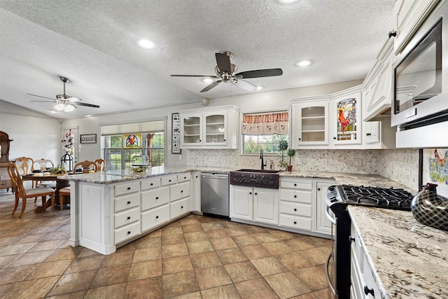 kitchen with stainless steel appliances, sink, white cabinets, and kitchen peninsula