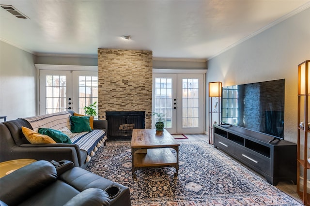 living room with ornamental molding, a healthy amount of sunlight, a fireplace, and french doors