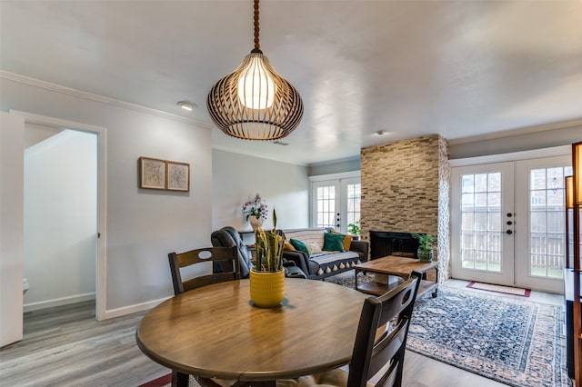 dining room with ornamental molding, light hardwood / wood-style flooring, and french doors