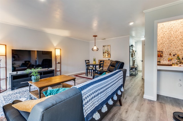 living room with ornamental molding and light hardwood / wood-style floors