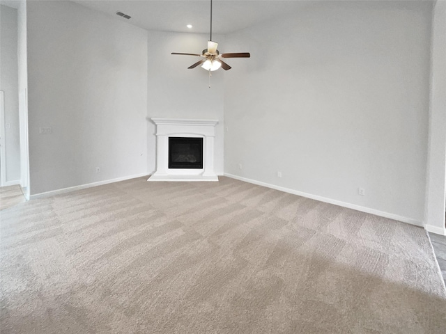 unfurnished living room featuring light carpet and ceiling fan