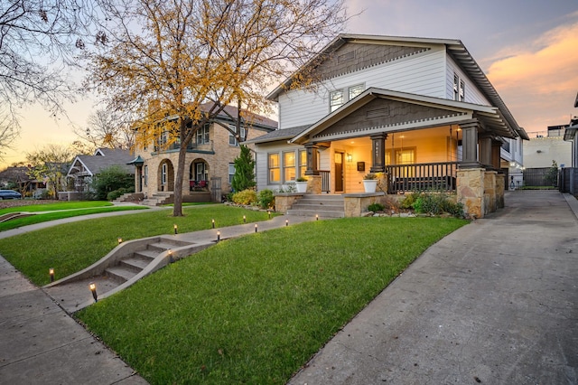 view of front facade with covered porch and a lawn