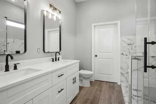 bathroom with vanity, toilet, a shower with door, and hardwood / wood-style floors