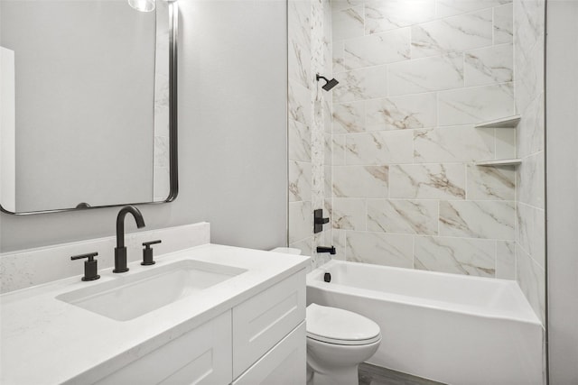 full bathroom featuring tiled shower / bath, vanity, and toilet