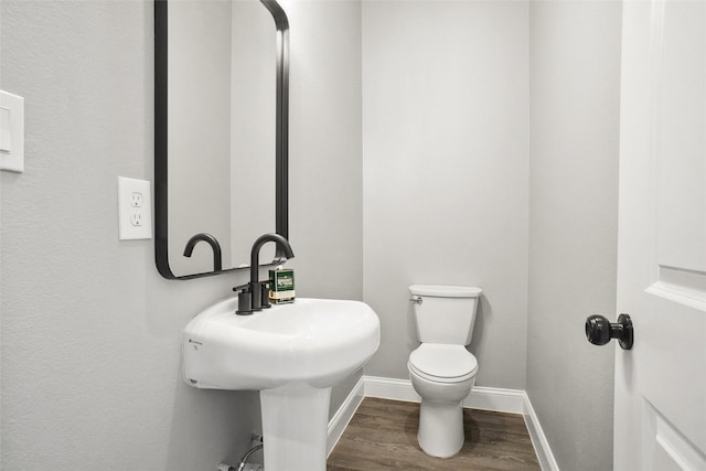 bathroom featuring hardwood / wood-style flooring and toilet