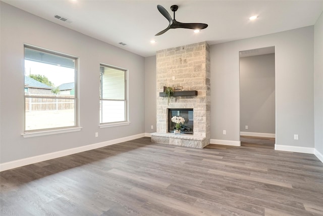 unfurnished living room with wood-type flooring, ceiling fan, and a fireplace