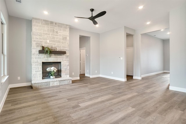 unfurnished living room featuring hardwood / wood-style floors, a fireplace, and ceiling fan