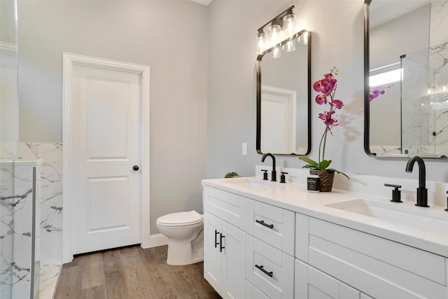 bathroom with vanity, toilet, hardwood / wood-style floors, and a shower