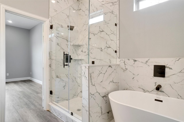 bathroom with tile walls, wood-type flooring, and separate shower and tub