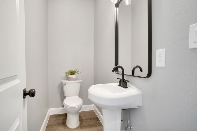 bathroom featuring wood-type flooring and toilet