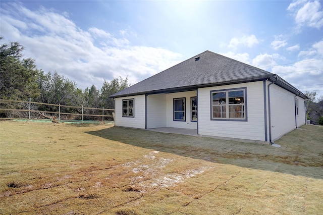 rear view of property featuring a patio and a lawn