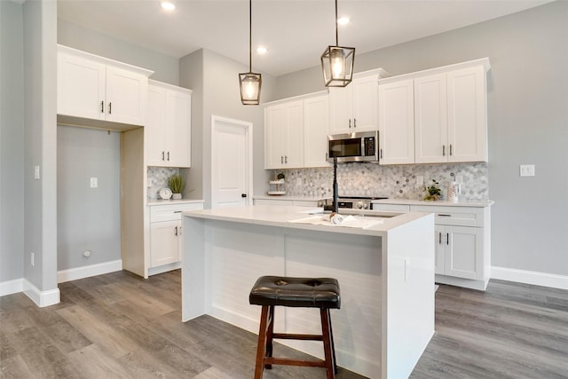 kitchen with white cabinetry and a center island with sink