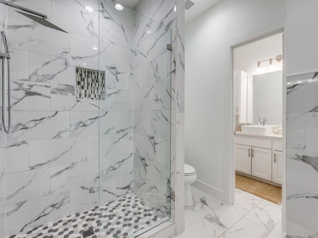 bathroom with tiled shower, vanity, and toilet