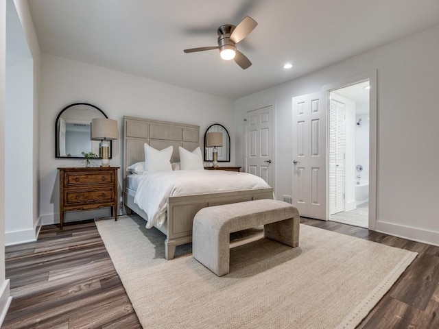 bedroom with dark wood-type flooring, ceiling fan, and ensuite bath