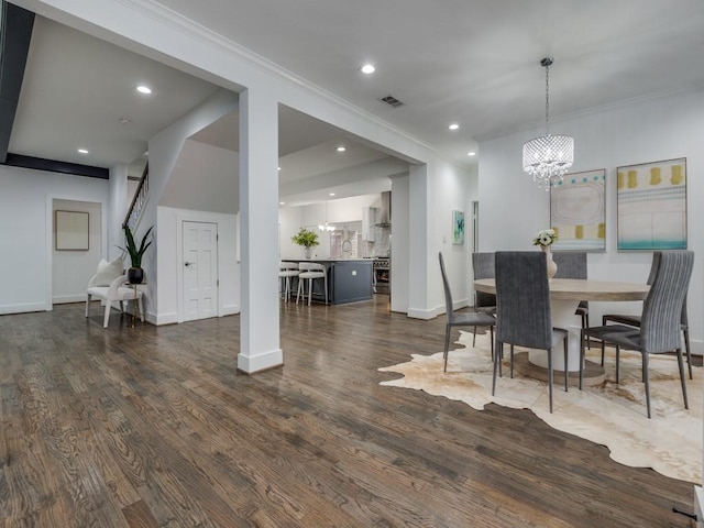 dining area with crown molding, dark hardwood / wood-style floors, and a chandelier