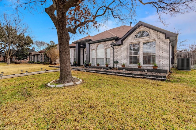 view of front of home featuring cooling unit and a front yard