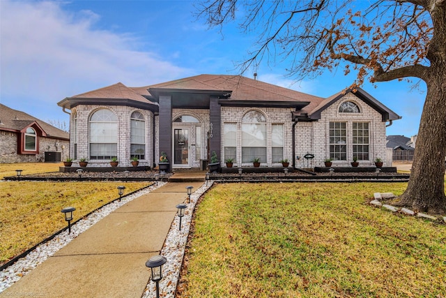 view of front facade with cooling unit and a front lawn