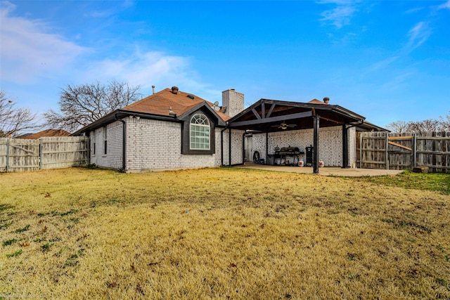 back of house featuring a lawn, a patio, and ceiling fan