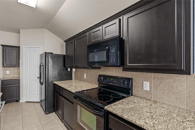 kitchen featuring light tile patterned floors, black appliances, light stone countertops, decorative backsplash, and vaulted ceiling