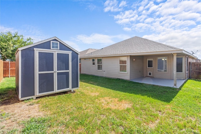 back of property featuring a patio area, a lawn, and a storage unit