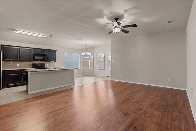 interior space with ceiling fan with notable chandelier, sink, and light hardwood / wood-style flooring