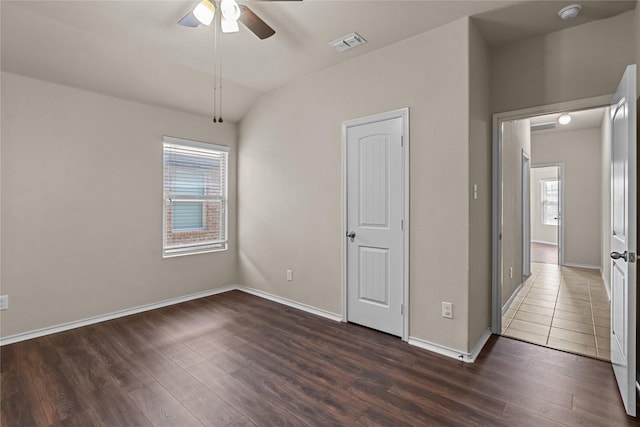 spare room featuring lofted ceiling, dark wood-type flooring, and ceiling fan