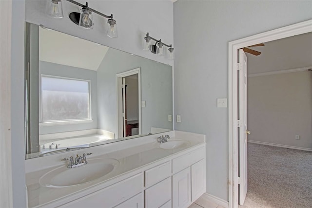 bathroom featuring lofted ceiling, a tub to relax in, and vanity