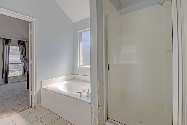 bathroom with lofted ceiling, tile patterned floors, and plus walk in shower