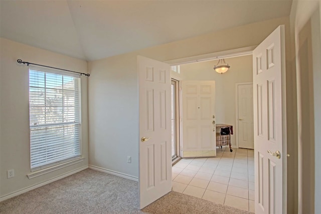 corridor with lofted ceiling and light colored carpet