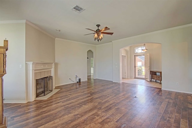 unfurnished living room featuring dark wood-type flooring, a fireplace, ornamental molding, and ceiling fan