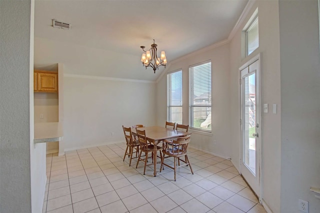 dining space with a notable chandelier, light tile patterned floors, and ornamental molding