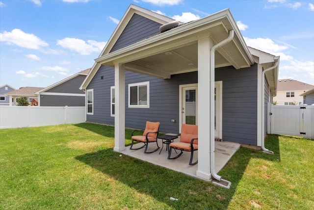 rear view of house with a patio and a lawn