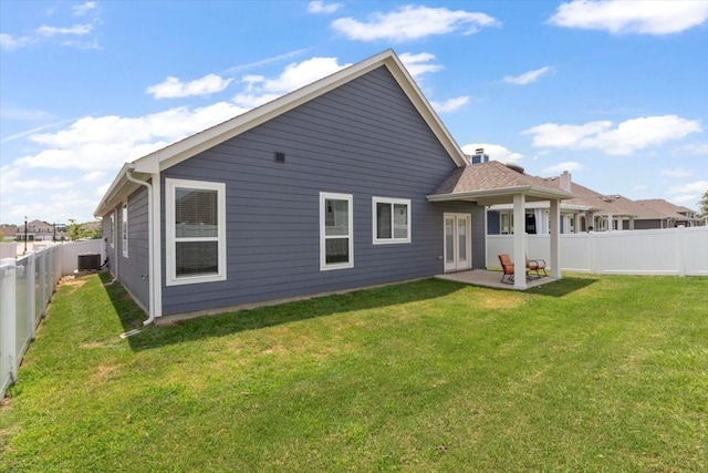 rear view of house with a patio and a lawn