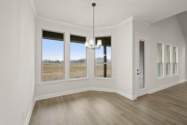 unfurnished dining area featuring baseboards, a chandelier, dark wood-type flooring, and ornamental molding