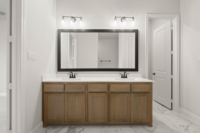 full bathroom with double vanity, marble finish floor, and a sink