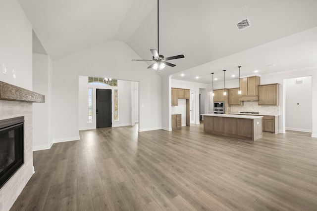 unfurnished living room with visible vents, baseboards, a ceiling fan, light wood-style flooring, and a fireplace