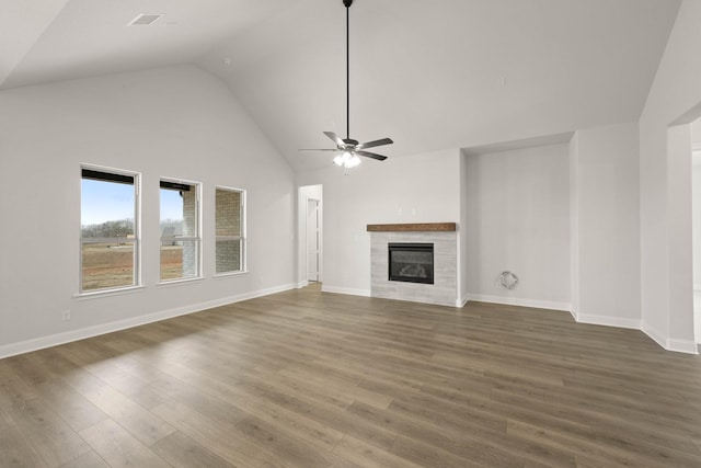 unfurnished living room with a tile fireplace, wood finished floors, a ceiling fan, and baseboards