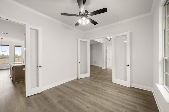 empty room featuring ornamental molding, french doors, a sink, and dark wood-style flooring