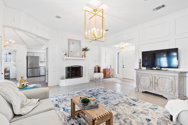 living room featuring ornamental molding, a brick fireplace, and a chandelier