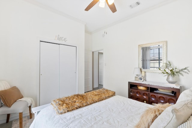 bedroom with ornamental molding, ceiling fan, and a closet