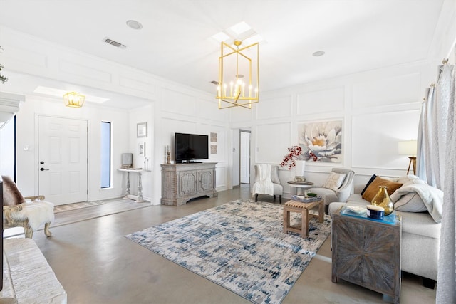 living room featuring an inviting chandelier, ornamental molding, and concrete floors