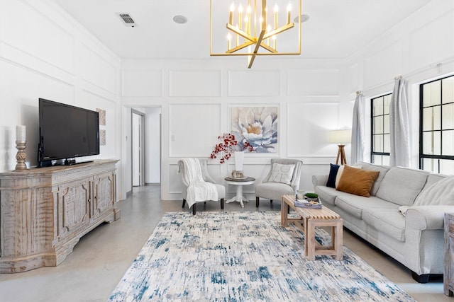 living room featuring concrete flooring, a notable chandelier, and ornamental molding