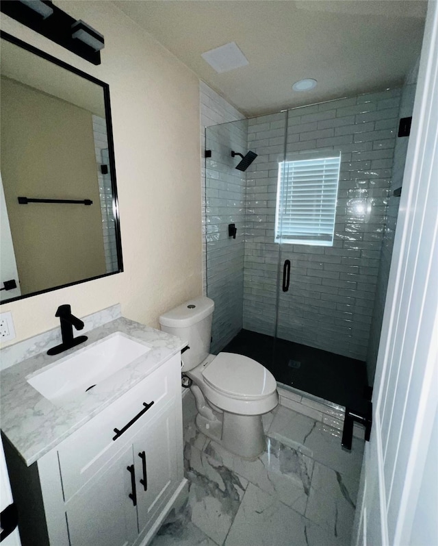 bathroom featuring vanity, a shower with door, and toilet