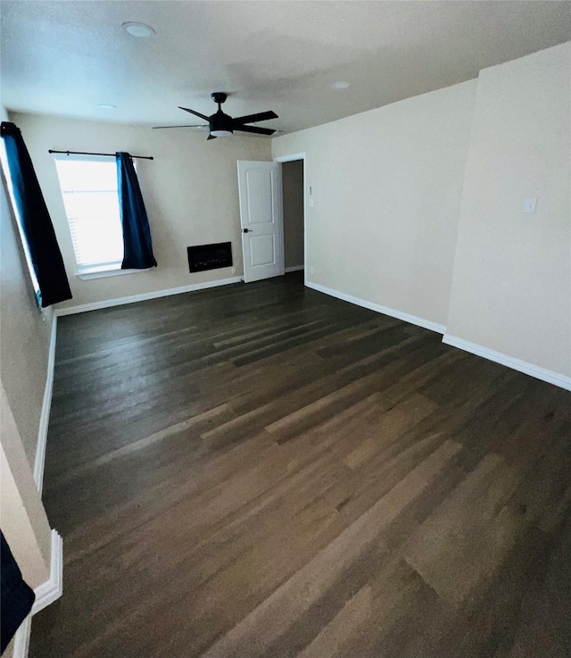 unfurnished room with ceiling fan and dark hardwood / wood-style flooring