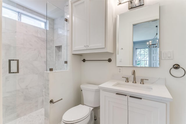 bathroom with vanity, toilet, a notable chandelier, and a shower with shower door