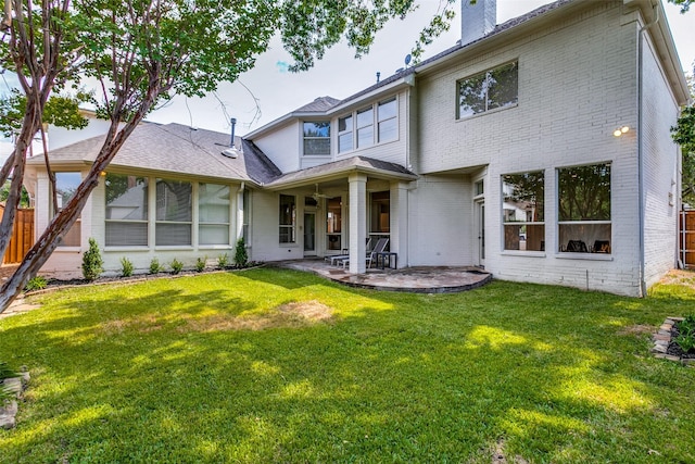 back of property with a lawn and a patio area