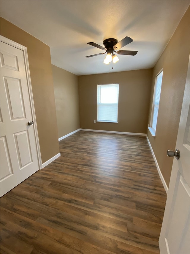 unfurnished room with ceiling fan and dark hardwood / wood-style flooring