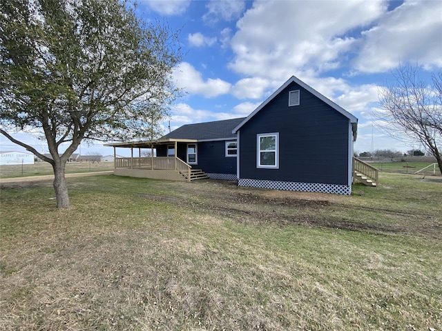 exterior space with a deck, a lawn, and a rural view