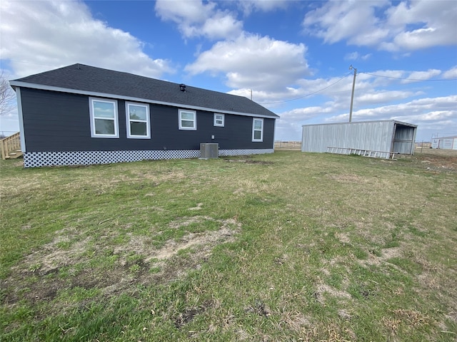 rear view of house with a yard and central air condition unit